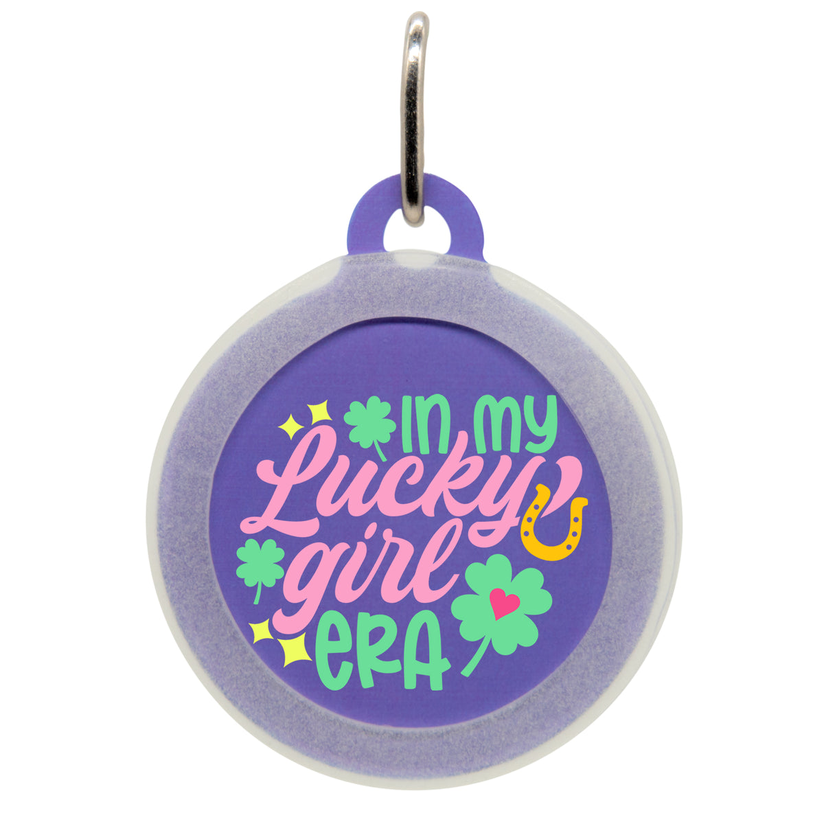 A purple pet ID tag with the text &quot;IN MY LUCKY GIRL ERA&quot; in colorful fonts, featuring shamrocks, a horseshoe, and sparkles. The tag has a small metal loop at the top for attaching to a collar.