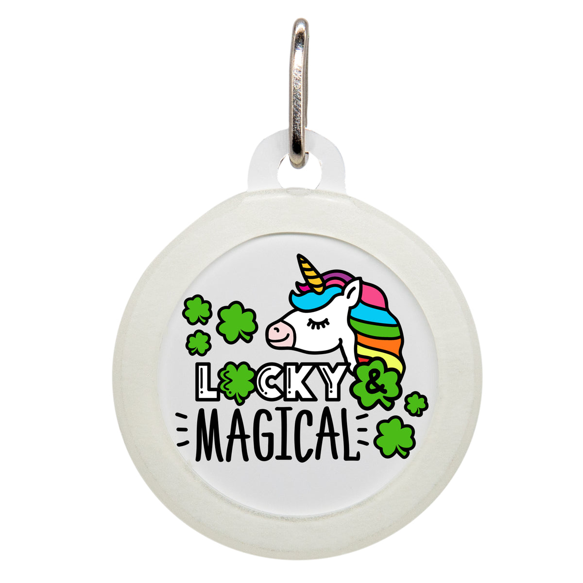 A white pet ID tag with the text &quot;LUCKY &amp; MAGICAL&quot; in black, featuring a colorful unicorn with a rainbow mane and shamrocks around it. The tag has a small metal loop at the top for attaching to a collar.